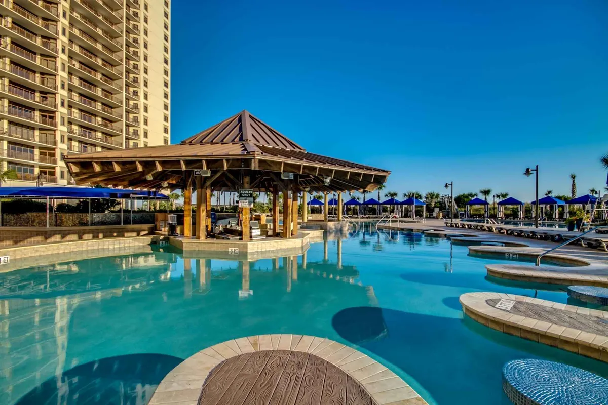 This image showcases an inviting backyard pool area complete with a gazebo, lounging chairs, and lush palm trees. The scene is vibrant and sunny, suggesting a perfect spot for families to relax, swim, or enjoy social gatherings just steps from their vacation home.